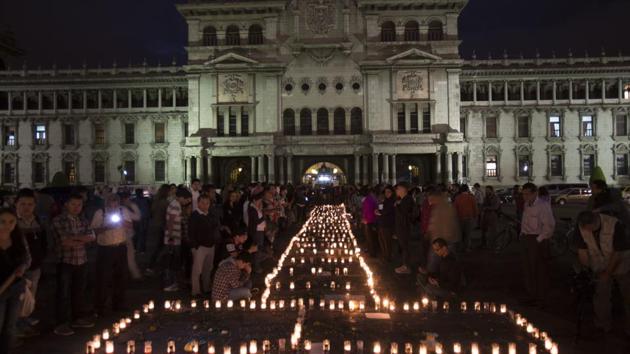 People hold a candlelight vigil outside the National Palace in remembrance of the girls who died in a fire at the Virgin of the Assumption Safe Home in Guatemala City. (AP) People hold a candlelight vigil outside the National Palace in remembrance of the girls who died in a fire at the Virgin of the Assumption Safe Home in Guatemala City. (AP)