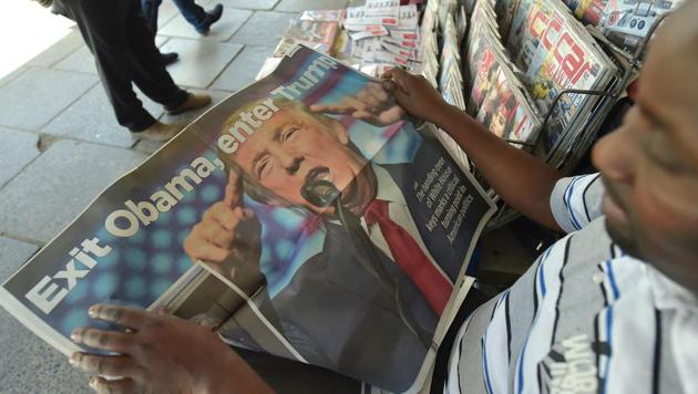 A man reads a newspaper pullout depicting US President Donald Trump. The president himself reads a a stack of newspapers — including The New York Times, The Wall Street Journal, The Financial Times, The Washington Post and The New York Post.(AFP File)