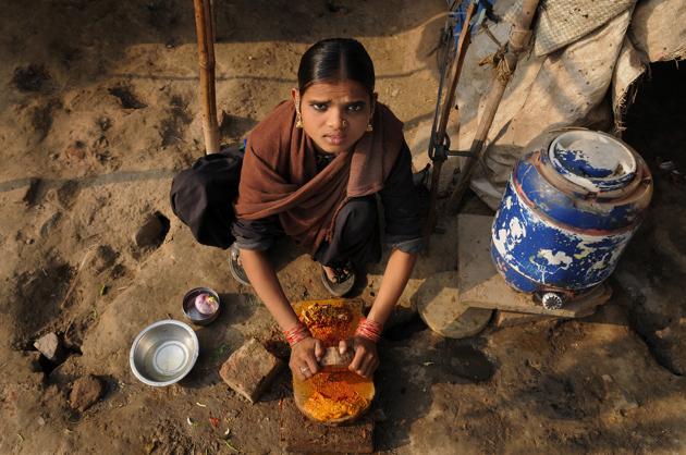 A woman makes fresh spices for her family of seven at a slum, Noida, Uttar Pradesh, India(Burhaan Kinu/HT)