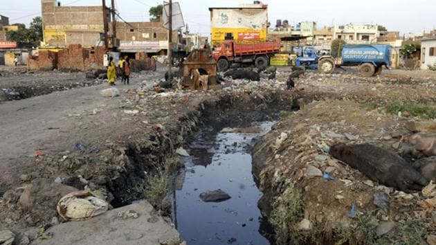An open sewer littered with garbage near Velocity Cinema at Ring Road in Indore. Several project proponents not implementing basic conditions such as not discharging waste water without treatment were found.(Shankar Mourya/Hindustan Times)