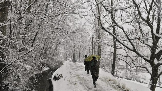 A Kashmiri man walks on a snow covered road on the outskirts of Srinagar on Friday March 10,2017. (Waseem Andrabi / HT photo)