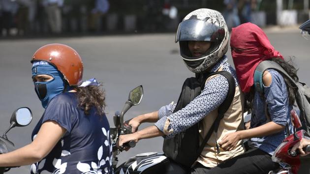 Mumbaiites cover their faces to avoid the sun in Mumbai on Thursday.(Arijit Sen/HT Photo)