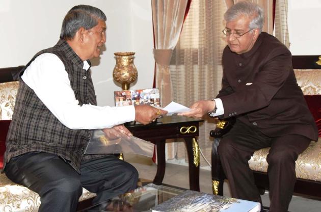 Chief minister Harish Rawat hands over his resignation to governor K K Paul in Dehradun on Saturday.(HT Photo)