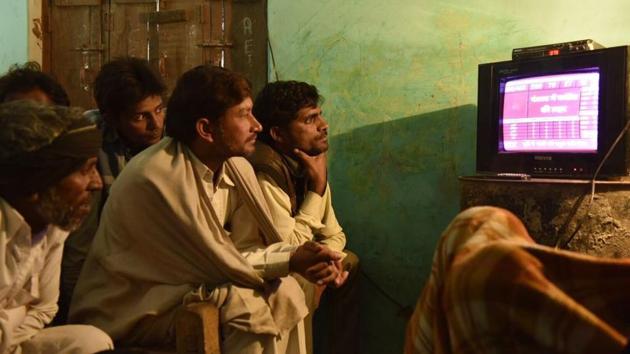 People in Jjogayi Khera in Muzaffarnagar seen glued to the TV to track results of the UP elections. (Saumya Khandelwal/HT Photo) 