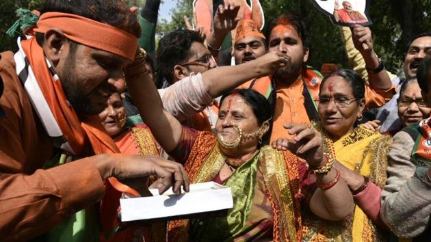 BJP supporters distribute sweets in anticipation of the party’s healthy performance, at the party headquarters in New Delhi. (Mohd. Zakir/HT Photo) 