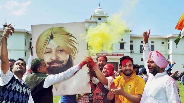 Congress workers celebrate in Patiala with a poster of Captain Amarinder Singh after the party’s thumping victory in the Punjab assembly polls on Saturday. (PTI) Congress workers celebrate in Patiala with a poster of Captain Amarinder Singh after the party’s thumping victory in the Punjab assembly polls on Saturday. (PTI)