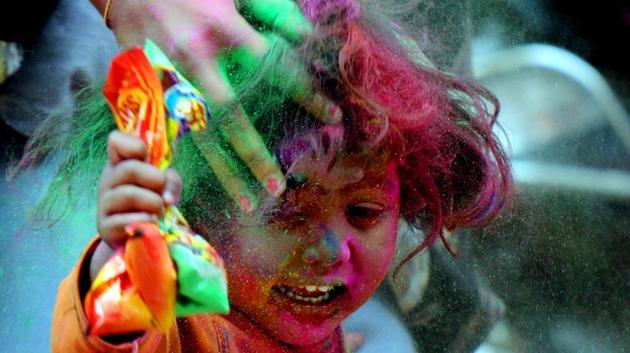 A child plays with gulal during the Holi celebration. (Parwaz Khan / HT Photo) 