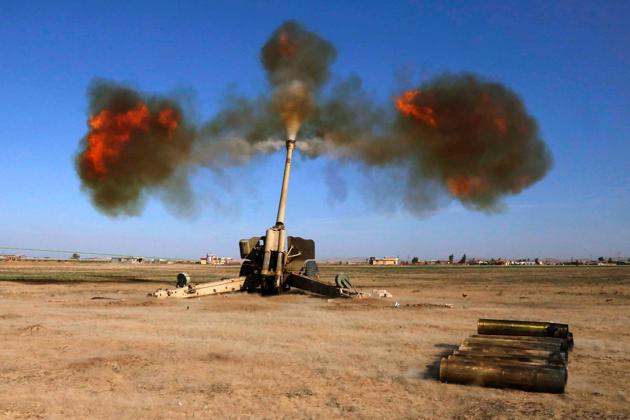 Iraqi fighters from the Abbas Brigade, which fights under the umbrella of the Shiite popular mobilisation units, fire towards enemy positions in village of Badush, some 15 kilometres northwest of Mosul, during the ongoing battle to retake the city's west from Islamic State (IS) group jihadists on March 9, 2017. (Mohammed SAWAF / AFP) 