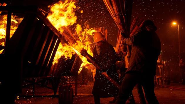 People light bundles of pinewood chips during the "Chienbase" procession on March 5, 2017 in Liestal, northern Switzerland. The procession takes place on the Sunday night after Ash Wednesday through the medieval town center. On this occasion, hundreds of people carry burning bundles of pinewood chips (called Chienbase, the Swiss German word for 'pinewood besom') (Michael Buholzer / AFP) 
