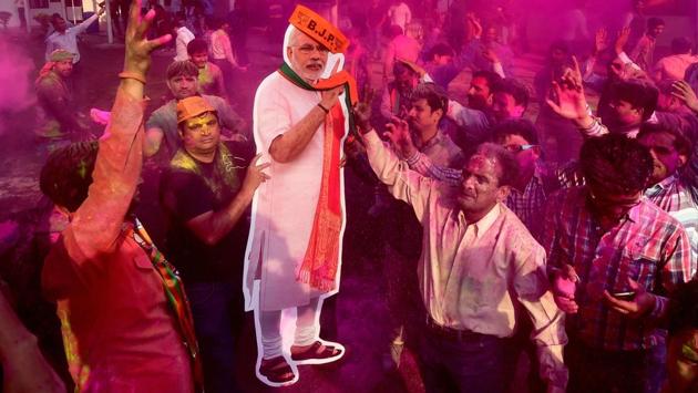 BJP workers play Holi with a giant cut-out of Prime Minister Narendra Modi as they celebrate the party’s victory. (Manvender Vashist / PTI) BJP workers play Holi with a giant cut-out of Prime Minister Narendra Modi as they celebrate the party’s victory. (Manvender Vashist / PTI)