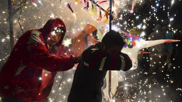 People run away from fireworks exploding around them next to a traditional ‘torito’ (little bull) - in Tultepec. (RONALDO SCHEMIDT / AFP) People run away from fireworks exploding around them next to a traditional ‘torito’ (little bull) - in Tultepec. (RONALDO SCHEMIDT / AFP)