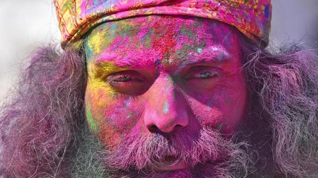 A Hindu devotee  covered in coloured powder  stands outside  the Durgiana Temple . (Gurpreet Singh / HT photo) 