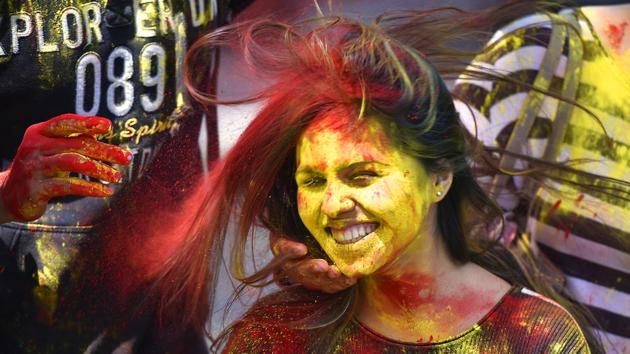 People smear colored powder on the face of a girl as they celebrate Hol in New Delhi. Celebrants light bonfires, throw colourful powder called gulal, eat sweets, and dance to traditional folk music. (Raj K Raj/HT PHOTO) People smear colored powder on the face of a girl as they celebrate Hol in New Delhi. Celebrants light bonfires, throw colourful powder called gulal, eat sweets, and dance to traditional folk music. (Raj K Raj/HT PHOTO)