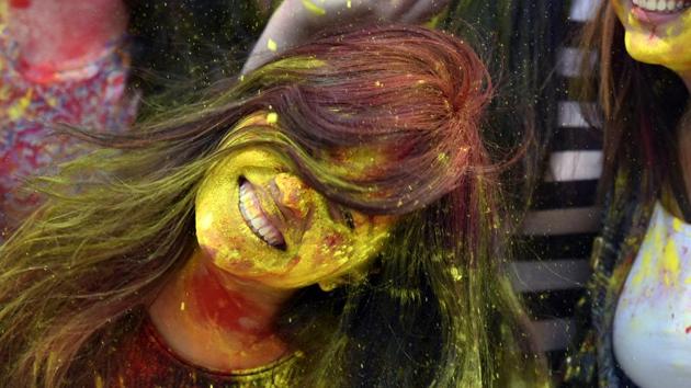 A woman shakes yellow gulal from her hair during Holi. (Raj K Raj/HT PHOTO) 