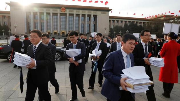 People carry stacks of papers near the Great Hall of the People after a plenary session of the Chinese People's Political Consultative Conference (CPPCC) in Beijing, China, March 11, 2017.(REUTERS)