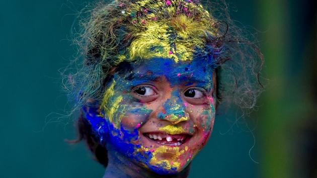 A child’s smile shines though the colours. (Kunal Patil/HT Photo) 