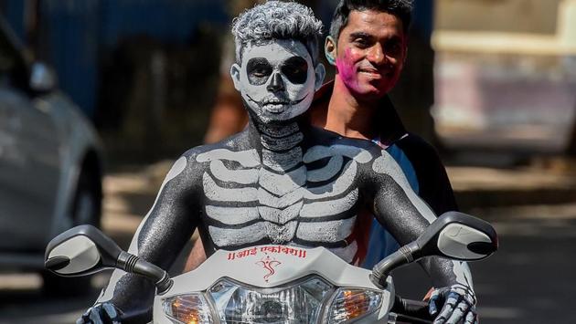 A reveller rides across the city after painting his body. (Kunal Patil/HT Photo) 