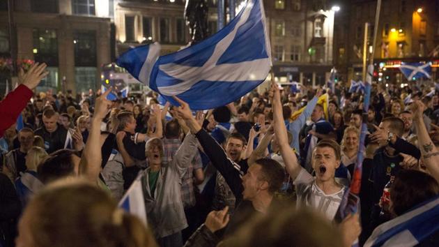Supporters of the Yes campaign in the Scottish independence referendum cheer with Scottish Saltire flags as they await the result after the polls closed, in George Square, Glasgow, Scotland, on September 18, 2014 .(AP File)