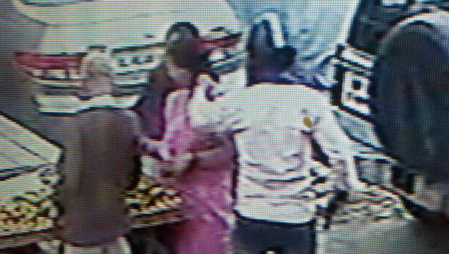 CCTV footage shows the robber, with a helmet covering his face, raise his pistol up to the woman in the market. CCTV footage shows the robber, with a helmet covering his face, raise his pistol up to the woman in the market.
