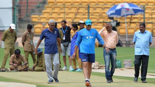 India’s cricket coach, Anil Kumble (centre) inspects the M Chinnaswamy Stadium pitch ahead of the second Test against Australia. ICC match rferee, Chris Broad, ruled the pitch ‘below average’ due to uneven bounce after the match ended in four days.(AFP)