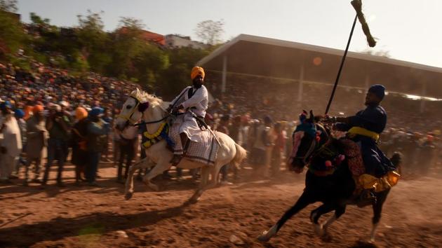 Nihangs ride their horses displaying tent pegging and other horse riding. The Hola Mohalla celebrations made its beginning around 1701 as Guru Gobind Singh wanted his troops to have mock battles to keep them battle-ready. (AFP) 