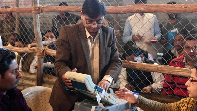 An EC official is demonstrating how an EVM functions to political agents at a counting centre.(AFP File Photo)