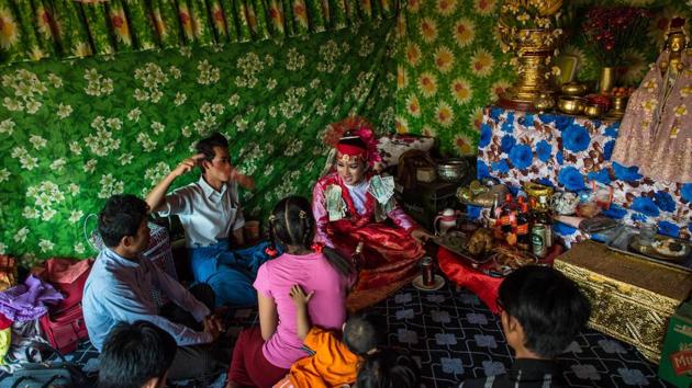 A medium sits among devotees inside a shrine in Shwe Ku Ni village. Each day of the two-week festival worshippers hold different events to honour Ko Gyi Kyaw, from bathing and gilding his statue to raucous cockfights. (Ye Aung Thu/AFP) A medium sits among devotees inside a shrine in Shwe Ku Ni village. Each day of the two-week festival worshippers hold different events to honour Ko Gyi Kyaw, from bathing and gilding his statue to raucous cockfights. (Ye Aung Thu/AFP)