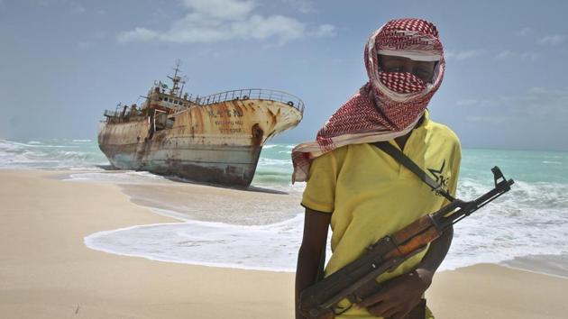 In this September 23, 2012 file photo, masked and armed Somali pirate Hassan stands near a Taiwanese fishing vessel washed ashore after the pirates were paid a ransom and the crew were released in the once-bustling pirate den of Hobyo, Somalia. (AP) In this September 23, 2012 file photo, masked and armed Somali pirate Hassan stands near a Taiwanese fishing vessel washed ashore after the pirates were paid a ransom and the crew were released in the once-bustling pirate den of Hobyo, Somalia. (AP)