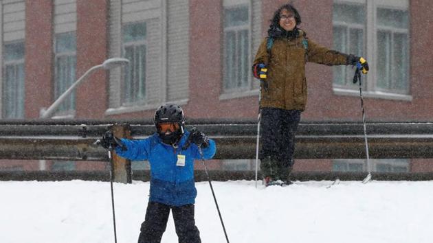 Harry Braunstien watches as his son Lucas skis during a snowstorm in the Brooklyn borough of New York City, U.S. (Brendan McDermid/REUTERS)