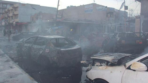 Burnt cars are seen at the site where a car bomb exploded in a crowded street in the Iraqi city of Tikrit , Iraq on March 15.(REUTERS)