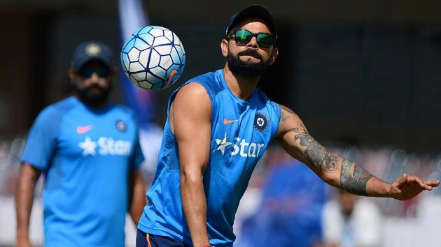 Virat Kohli (R) plays football with Indian cricket teammates during a training session ahead of the third Test against Australia in Ranchi.(AFP)