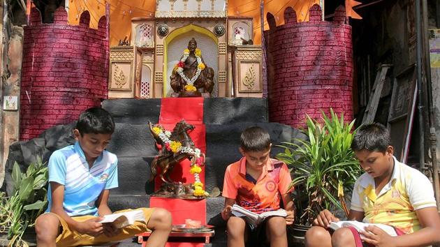 LEARNING THE RIGHT LESSONS: Children study near a statue of Shivaji Maharaj in Byculla. (Bhushan Koyande/HT Photo)
