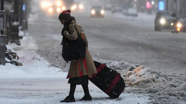 A woman pulls a suitcase along a snow and sleet covered street of New York. (Jewel Samad/AFP)