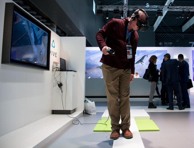A visitor uses a virtual reality device during the Mobile World Congress on the third day of the MWC in Barcelona, on March 1, 2017.(AFP) A visitor uses a virtual reality device during the Mobile World Congress on the third day of the MWC in Barcelona, on March 1, 2017.(AFP)