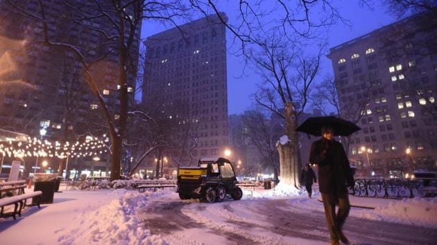 A man clears the sidewalk near Madison Square Park at the foot of the Flatiron building in Manhattan during a snowstorm in New York. (Eric Baradat/AFP)