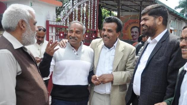BJP leaders share a joke outside the party office in Dehradun on Thursday.(Vinay Santosh Kumar/HT Photo)