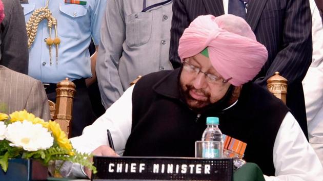 Amarinder Singh signs a document after taking oath as the Chief Minister of Punjab in the presence of Governor V P Singh Badnore at the Raj Bhavan in Chandigarh. (PTI) 