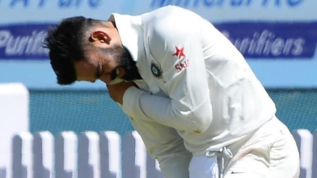 Virat Kohli holds his shoulder in pain after getting injured while fielding during the first day of the third Test against Australia cricket team in Ranchi on Thursday.(AFP)