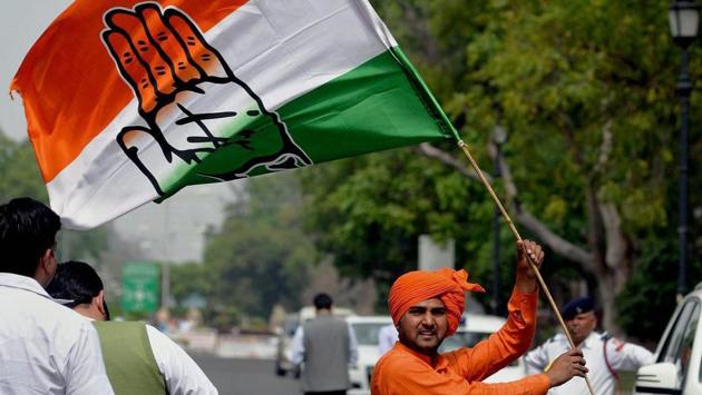 A supporters of Congress party waves party flag as  Capt. Amarinder Singh and team take oath. (PTI) 