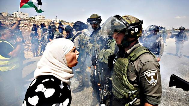A Palestinian woman argues with an Israeli border policeman during a protest against Jewish settlements in the West Bank village of Nabi Saleh, near Ramallah. (Reuters File Photo) A Palestinian woman argues with an Israeli border policeman during a protest against Jewish settlements in the West Bank village of Nabi Saleh, near Ramallah. (Reuters File Photo)