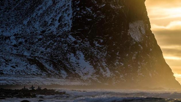 Surfers wait for the right moment to enter the water in Unstad along the northern Atlantic Ocean. (Olivier Morin/AFP) Surfers wait for the right moment to enter the water in Unstad along the northern Atlantic Ocean. (Olivier Morin/AFP)
