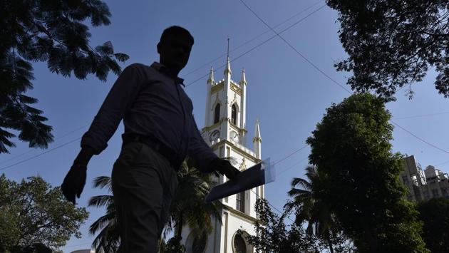 Clock towers were a departure from the decorative and religious motifs so popular in traditional architecture. They were in fact a reflection of the time – a shift towards utility, usefulness, and the start of a movement to maximize productivity. A busy Mumbaikar is seen here passing by the 298 year old St. Thomas Cathedral at  Horniman Circle. 