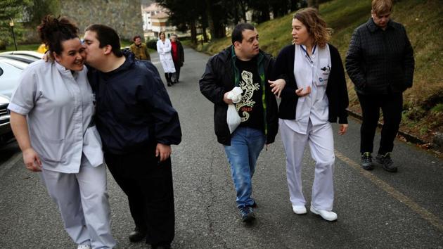 Inaki Gorriz (L) kisses social worker Irune Alchu, as Andres Garcia (C) walks hand in hand with nurse Andre Carricaburu while going for a walk with "Argi" and "Atila”. The facility, based in a town near the border with France, uses the dogs to help patients with intellectual disabilities and mental health conditions develop social skills and a sense of autonomy. (Susana Vera/REUTERS) Inaki Gorriz (L) kisses social worker Irune Alchu, as Andres Garcia (C) walks hand in hand with nurse Andre Carricaburu while going for a walk with "Argi" and "Atila”. The facility, based in a town near the border with France, uses the dogs to help patients with intellectual disabilities and mental health conditions develop social skills and a sense of autonomy. (Susana Vera/REUTERS)