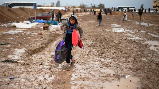 A displaced Iraqi makes his way to get into Hamam al-Alil camp, on a rainy day, south of Mosul. (Suhaib Salem / REUTERS)