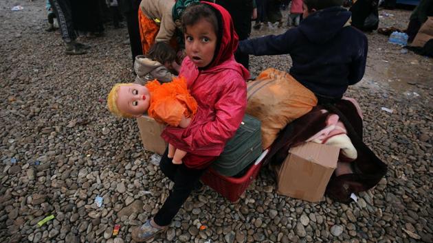 An Iraqi girl, displaced from Mosul, hugs her toy at the Hammam al-Alil camp for the internally displaced, south of Mosul, during an offensive by security forces to retake the western parts of the city from Islamic State (IS) group fighters. (AHMAD AL-RUBAYE / AFP)