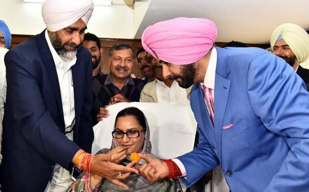 Manpreet Badal and Navjot Singh Sidhu offering sweets to colleague Razia Sultana at the Punjab secretariat in Chandigarh on Friday. (HT Photo) Manpreet Badal and Navjot Singh Sidhu offering sweets to colleague Razia Sultana at the Punjab secretariat in Chandigarh on Friday. (HT Photo)