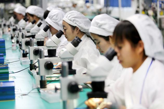 This photo taken on March 7, 2017 shows Chinese employees working on micro and special motors for mobile phones at a factory in Huaibei, east China's Anhui province.(AFP)