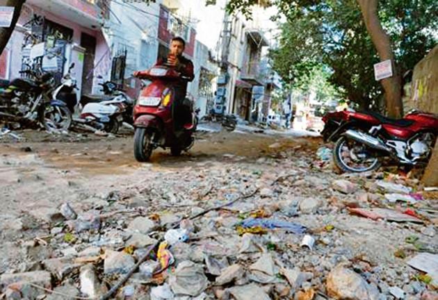 A damaged road in block U of DLF Phase 3.(Parveen Kumar/HT FILE)