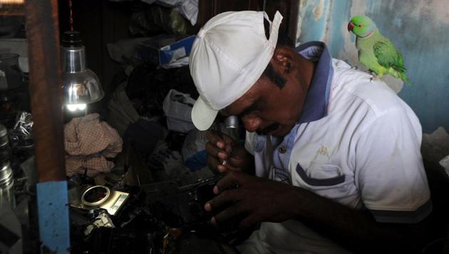 Indian camera technician and parakeet enthusiast Joseph Sekar, 62, repairing a camera with a parakeet on his shoulder at his home in Chennai. (ARUN SANKAR / AFP) Indian camera technician and parakeet enthusiast Joseph Sekar, 62, repairing a camera with a parakeet on his shoulder at his home in Chennai. (ARUN SANKAR / AFP)