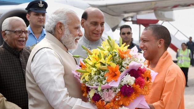 Prime Minister Narendra Modi being offered a bouquet by Yogi Adityanath, on his arrival in Lucknow, Uttar Pradesh on Sunday.(PTI Photo)